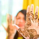 Close-up of a woman's hand with intricate henna design, symbolizing tradition and artistry.